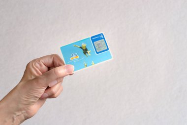 Almanya 'daki Dm-drogerie markt mağazalarından bir geri ödeme kartı tutan kadın. Düz yapılandırılmış arkaplan.