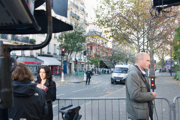 Journalists reporting about the Bataclan cafe killings in November 15, 2015. The street around the Bataclan were closed and guarded by French police agents. Bataclan cafe in the background. Boulevard Voltaire, Paris; France.
