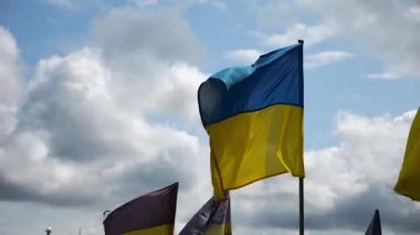 View on blue-yellow flags at countless graves of ukrainian soldiers alley of glory in Kharkiv. This site commemorates heroes and maintains the memory of wartime events in Ukraine. Slow mo