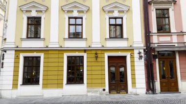 Tarihi şehir mimarisi manzarasında geleneksel konut binaları yer alıyor. Ön cephelerde klasik tasarım unsurları, ayrıntılı pencereler ve dokulu duvarlar, kültür mirası kentsel ortamının yakalanması yer alıyor.