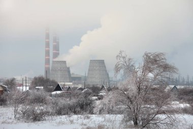 CHP yakınlarındaki köyde kış manzarası ev ve ağaçlarla kaplıydı.