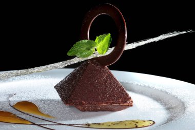 Çikolata ve reçelle süslenmiş beyaz bir tabakta nefis bir tatil tatlısı.