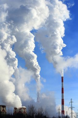 Mavi gökyüzüne karşı bitkinin bacasından izole edilmiş beyaz duman.