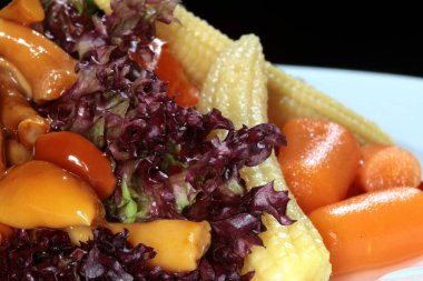 Verusyonla dekore edilmiş beyaz bir tabakta çeşitli turşular.