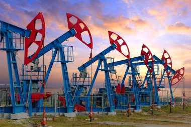 Gün batımında dramatik bulutların arka planında petrol pompalarının yakın plan görüntüleri