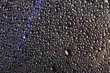 Gri zemin üzerinde cam üzerindeki su damlacıklarının yakın çekim dokusu