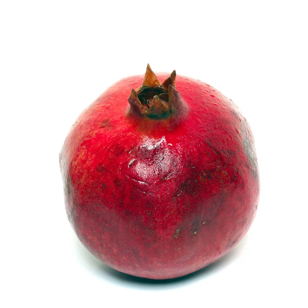 Kabuktaki olgun kırmızı bir nar kabuğunun yakın plan görüntüsü beyaz zemin üzerinde izole edilmiş.