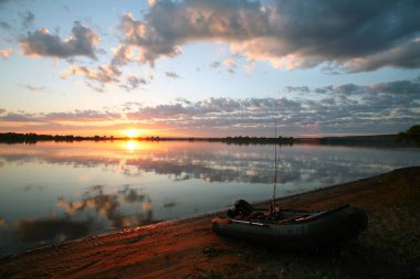 Sakin bir nehrin üzerinde harika bir gün batımı.