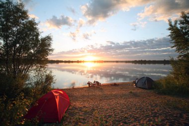Sakin bir nehrin üzerinde harika bir gün batımı.