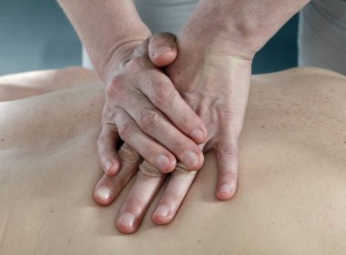 Masörün elleri izole edilmiş. Bir seans sırasında erkeğin sırtındaki kadın. Stüdyo.