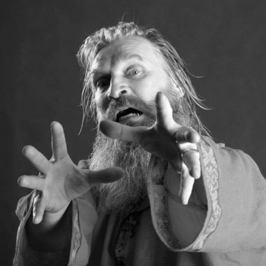 Kırmızı gömlek stüdyosunda uzun sakallı, bıyıklı ve ıslak sarı saçlı kutsanmış birinin yakın plan portresi.