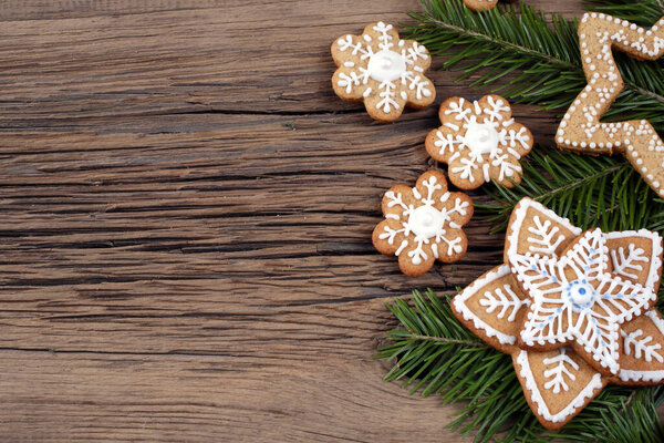 close-up still-life of fir branches and the gingerbread with pattern on magic Christmas holiday on background a wooden boards studio