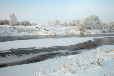 Sabahın erken saatlerinde karla kaplı tarlalar, ağaçlar ve nehirlerin kış manzarası