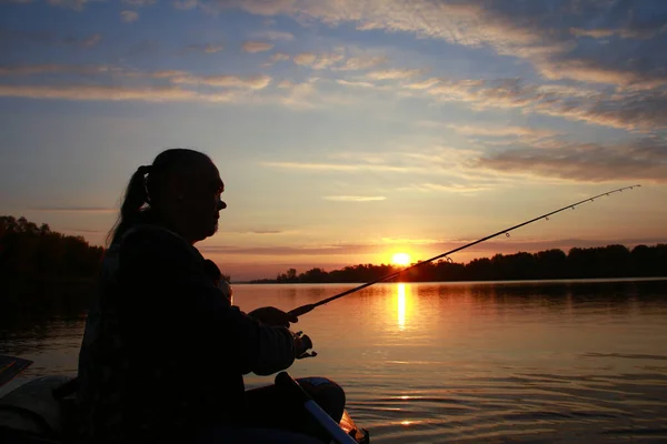 秋の日没時に釣竿を手に川の舟に乗った男の肖像画 — ストック写真