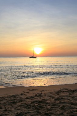 Deniz manzaralı gün batımı ve Tayland kıyılarında sönük yelkenli bir tekne.