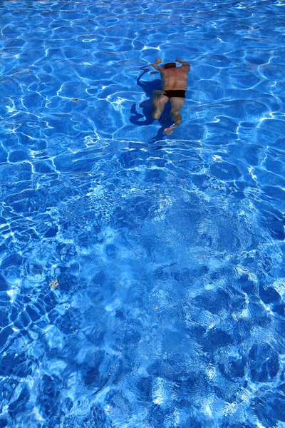隔离的蓝色水池和水里的游泳者 — 图库照片