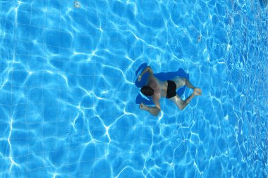 İzole edilmiş gök mavisi su havuzu ve suda yüzücü. 