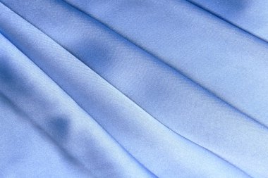 Mavi kumaşın makro dokusu stüdyoyu katlıyor.