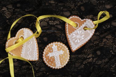 Siyah arka plan stüdyosuna asılmış sarı bantlı kalp şeklinde zencefilli paskalya pastası.