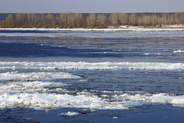 Baharda güneşli bir günde nehir üzerindeki buz tabakası sürükleniyor. 