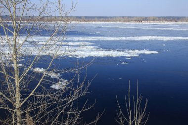Baharda güneşli bir günde nehir üzerindeki buz tabakası sürükleniyor. 