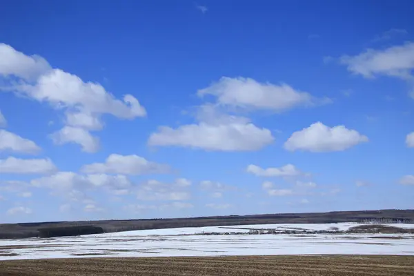 Vår Landskap Snö Smälter Fältet Och Vita Moln Blå Himmel — Stockfoto