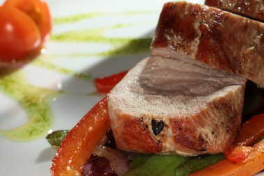 Siyah arka plan stüdyosundaki beyaz bir tabakta sebzeli etin yakın plan çekimi.