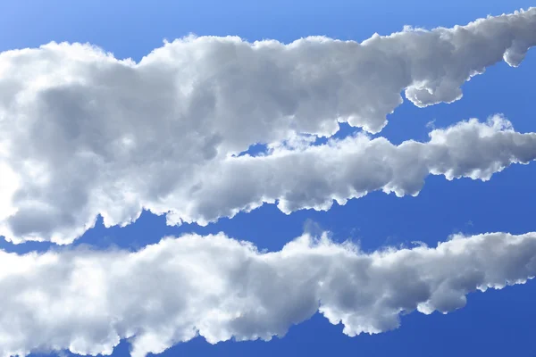 Vit rök mot den blå himlen — Stockfoto