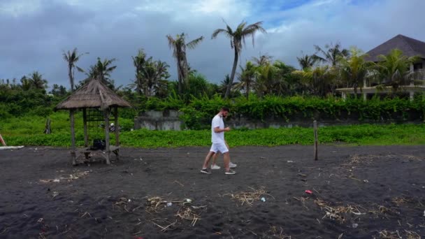 Couple Walk Deserted Beach Black Sand Lot Trash Wearing Masks — Stock Video