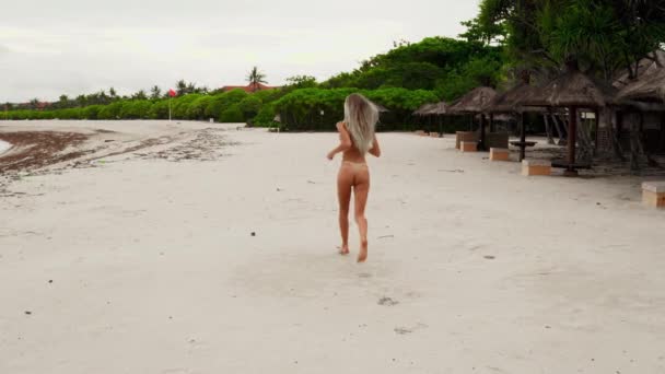 Κορίτσι Τρέχει Μια Λευκή Παραλία Ευτυχισμένη Και Φωτεινή Ξανθιά — Αρχείο Βίντεο