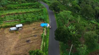 Batur Dağı 'nın eteğindeki yol uçuşunun yüksekliğinden itibaren, kart mobiletin hareketini izler.