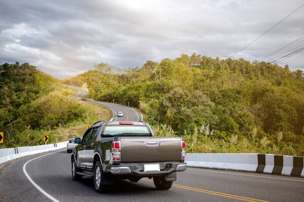 Rear view of pickup truck on wavy road, Many cars running on the beautiful road along the mountain