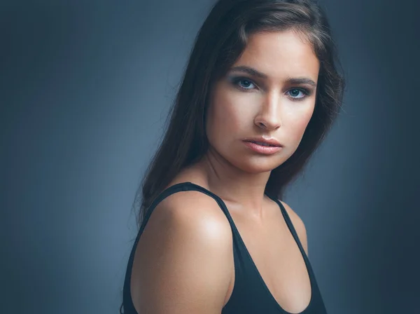 Mujer hermoso retrato de estudio con pelo largo y oscuro sobre fondo oscuro — Foto de Stock