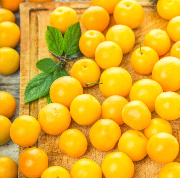 Ciruelas de cerezo sobre tabla de cortar de madera — Foto de Stock