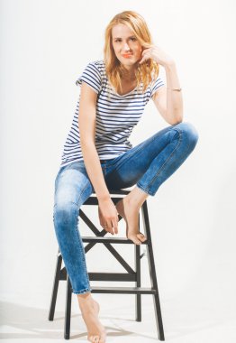 çekici genç kadın sandalyede oturuyor