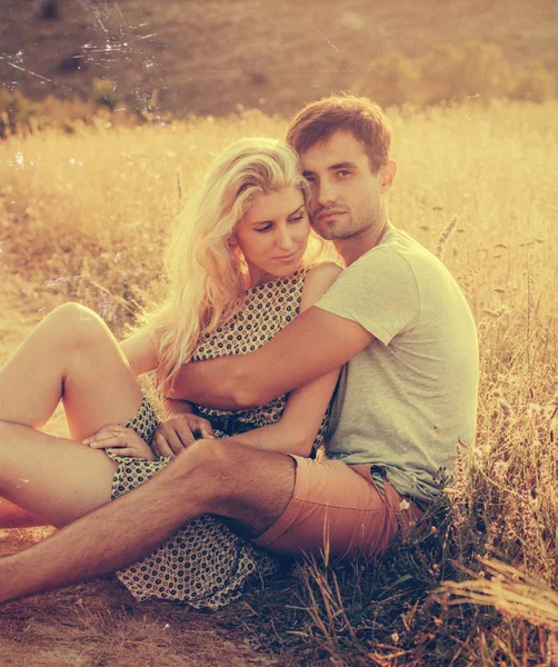 Hermoso paisaje y pareja enamorada de flores en la puesta del sol personas felices al aire libre — Foto de Stock