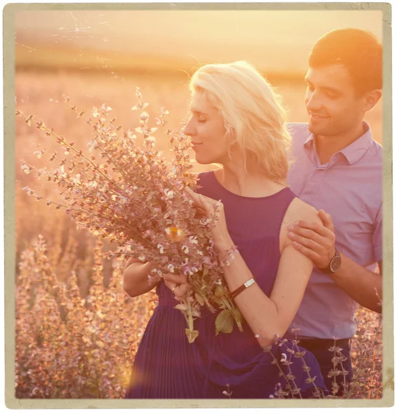 Bela paisagem e casal apaixonado por flores no pôr do sol pessoas felizes ao ar livre — Fotografia de Stock