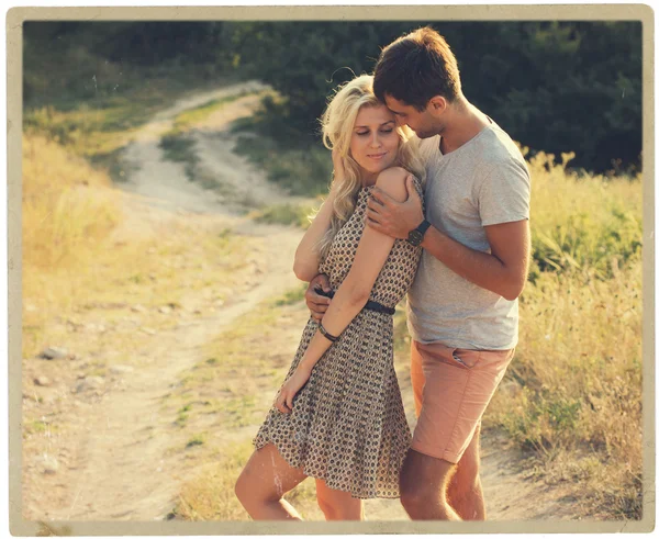 Hermoso paisaje y pareja enamorada de flores en la puesta del sol personas felices al aire libre — Foto de Stock