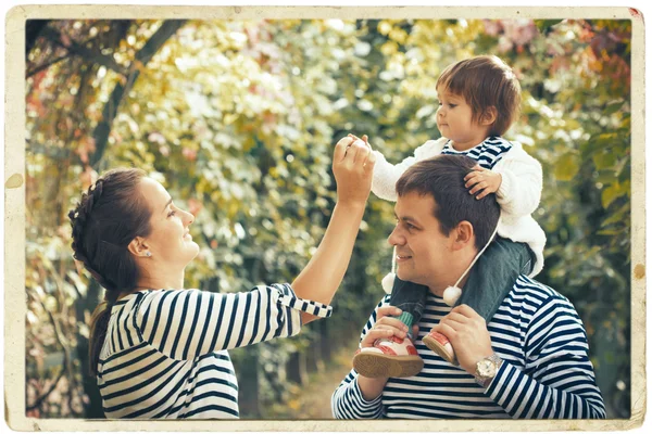 Familia juntos en la naturaleza en rayas misma ropa — Foto de Stock