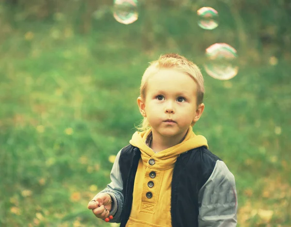 Garçon regardant des bulles de savon — Photo