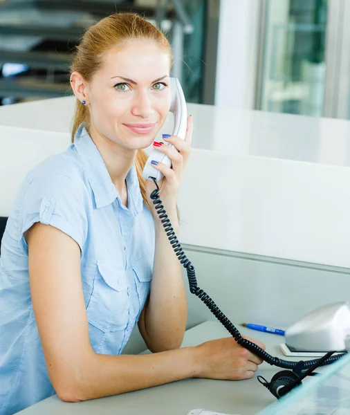 Woman talking on phone at workplace — Stock Photo, Image