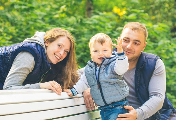 Família sentada no banco de madeira — Fotografia de Stock