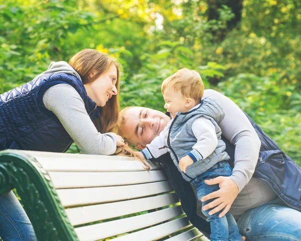 Família sentada no banco de madeira — Fotografia de Stock