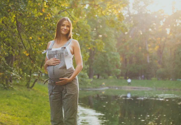 Беременная женщина на природе счастлива — стоковое фото