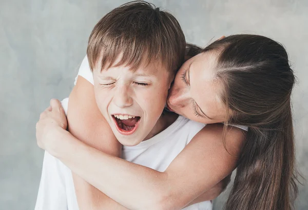 Familienmutter Küsst Lächelnden Sohn lizenzfreie Stockbilder