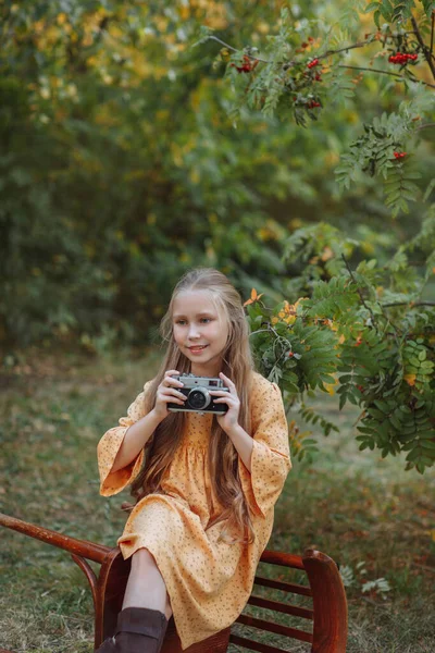Χαμογελαστό Ξανθό Κορίτσι Κίτρινο Vintage Φόρεμα Κρατώντας Ρετρό Κάμερα Εξωτερική — Φωτογραφία Αρχείου
