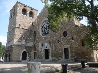 Trieste 'deki San Giusto Katedrali. Büyük bir gül penceresi ve tuğladan yapılmış çan kulesi var.