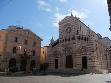 San Lorenzo Katedrali ve Grosseto 'daki belediye sarayı, Katedral' in ön cephesi, küçük bir teras ve belediye sarayının saati olan peçeli..