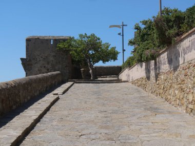 Castiglione della Pescaia tahkimatlarının iç kısmı. Ön planda, çevreleyen duvar ve surlar ve arka planda, Tiren Denizi kıyısı ile kesişiyordu.