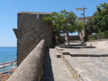 Castiglione della Pescaia tahkimatlarının iç kısmı. Ön planda, çevreleyen duvar ve surlar ve arka planda, Tiren Denizi kıyısı ile kesişiyordu.